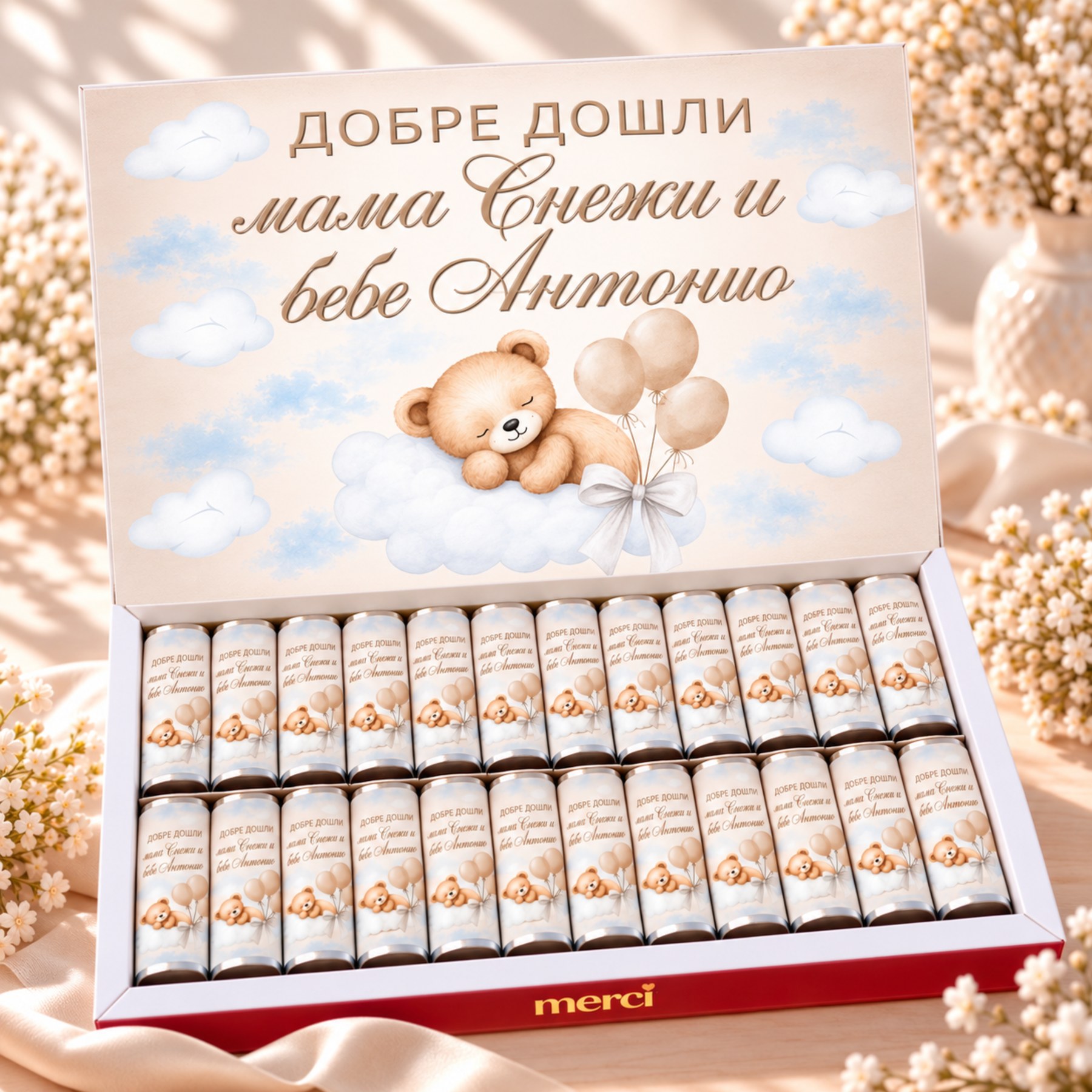 Персонализирана кутия бонбони MERCI за изписване на бебе с надпис „Добре дошли мама Снежана и бебе Антонио“